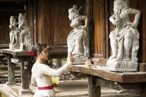 Lady placing an offering bowl at a temple.