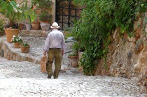 Old man walking down a cobble street in Fornalutx on the island of Mallorca