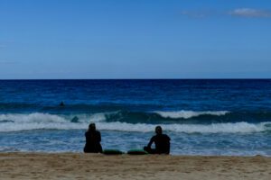 Two surfers sitting on the beach of Corralejo in Fuerteventura