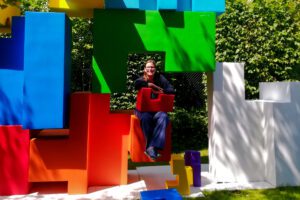 Renata Green sitting in the art installation Childhood Block by LEUNG Hongman.