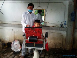 Boy getting a haircut in Phnom Penh, Cambodia